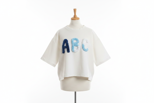White oversized t-shirt with blue ABC appliqué on mannequin with white background
